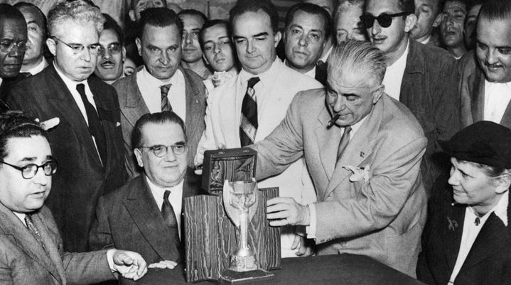 Les représentants de la fédération italienne, dont Ottorino Barassi (assis, cravate sombre), transmettent le trophée à leurs homologues brésiliens, organisateurs de la compétition qui va démarrer, le 22 juin 1950, à Rio de Janeiro (Brésil). (STAFF / INTERCONTINENTALE / AFP)